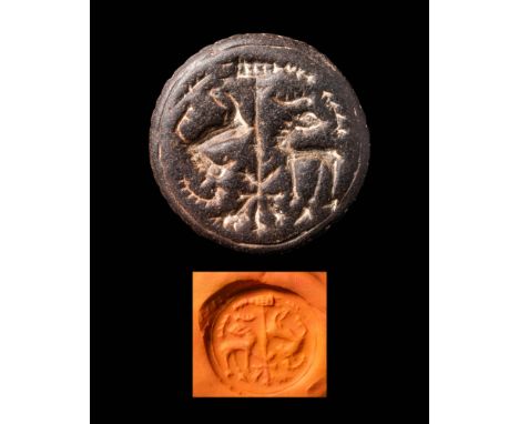 Ca. 2300 - 1800 BC.A round Bactrian stamp seal depicting two horned animals facing each other in the forest. The reverse is d