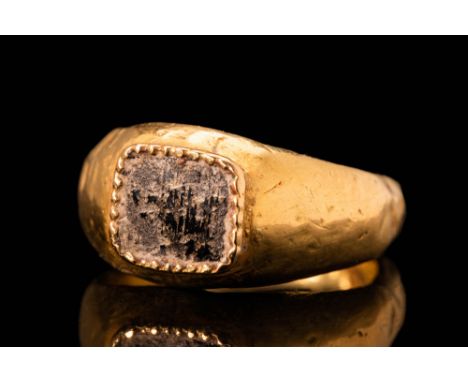 Ca. AD 400 - 500.A Roman 18.5 ct gold finger ring with a square shaped bezel and hard-stone set in a gold frame with wavy mot