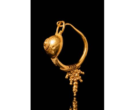 Ca. AD 200 - 300.A large Roman 21.5 ct gold earring with a small umbo shield design attached by a granule and framed by filig