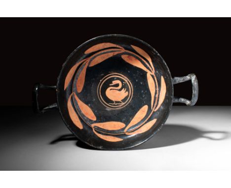 Ca. 340 - 325 BC.A beautiful Apulian pottery kylix with a low foot, shallow bowl and two sloping handles. The vessel is decor