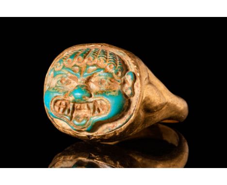 Ca. AD 100 - 300.A Roman 21 ct gold ring with a turquoise faience cameo shaped like a gorgon head. The curls fall across the 