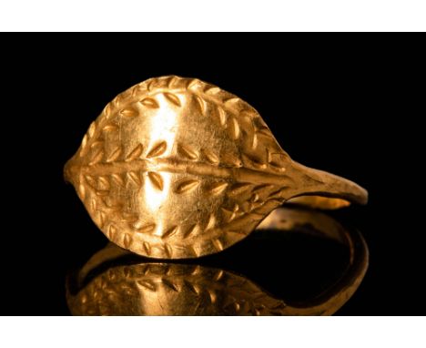 Ca. AD 100 - 300.A Roman 23 ct gold ring with large bezel decorated with laurel wreath motifs on the edges and double line in