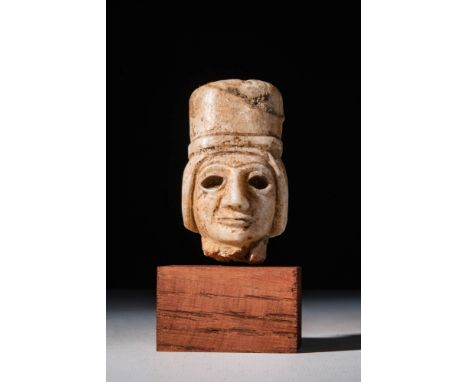 Ca. 2900 - 2300 BC.A Sumerian head of statuette with headdress depicting a male figure with a cylindrical hat and simple coif