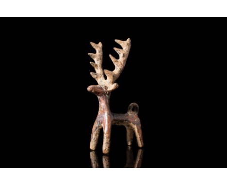 Ca. 1st millennium BC.A bronze freestanding figurine depicting a stag. The animal features an uplifted neck that gracefully e