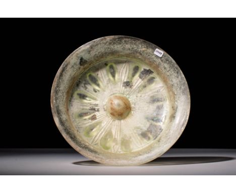 Ca. 500 - 300 BC.A Greek phiale in a pale green glass with a simple everted rim, hemispherical bowl, and base. The bottom is 