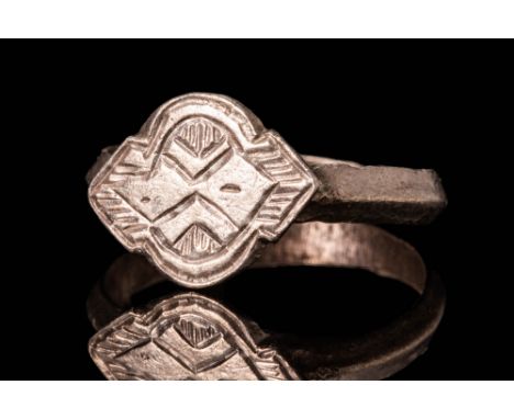 Ca. AD 1300 - 1400.A Western European Medieval silver ring with shield shaped bezel. It has a round hoop with a polygonal sec