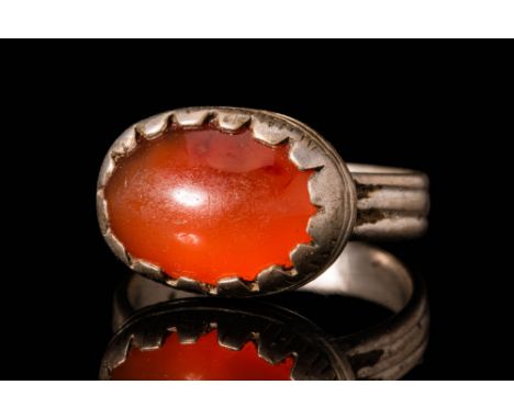 Ca. AD 1200 - 1300 .A Medieval Byzantine silver ring with a red carnelian cabochon set in an oval bezel connected to a round 