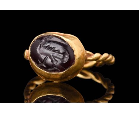 Ca. AD 600 - 800.A gold ring featuring a round-section twisted hoop that elegantly wraps around the finger, creating a delica