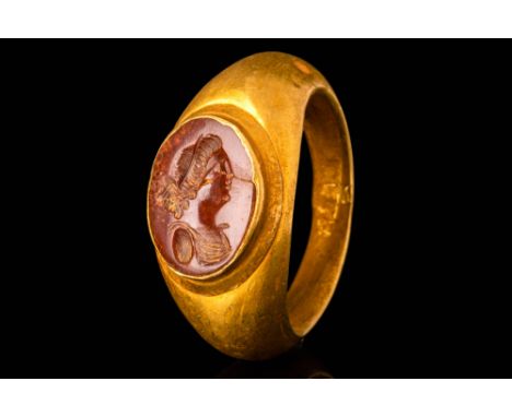 Ca. AD 100 - 300.A Roman 22 ct gold finger ring with a jasper intaglio depicting a young woman. The woman wears a sleeveless 