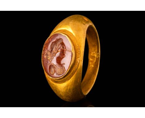 Ca. AD 100 - 300.A Roman 22 ct gold finger ring with a jasper intaglio depicting a young woman. The woman wears a sleeveless 