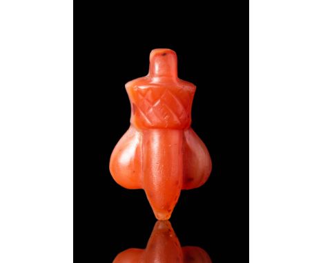 Ptolemaic to Roman Period, Ca. 100 BC - AD 100 .A Egypto-Roman carnelian pendant depicting a phallic form on top of a lotus c