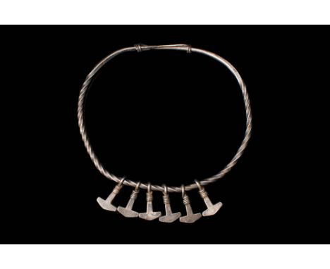 Ca. AD 700 - 1000.A rare Viking scandinavian silver twisted torque with knot type clasp. It is adorned by six Mjolnir (Thor's