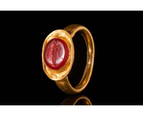 Ca. AD 100 – 300.A Roman 23.5 ct gold ring composed of a flat section hoop, culminating in a bezel set with an oval-shaped ca