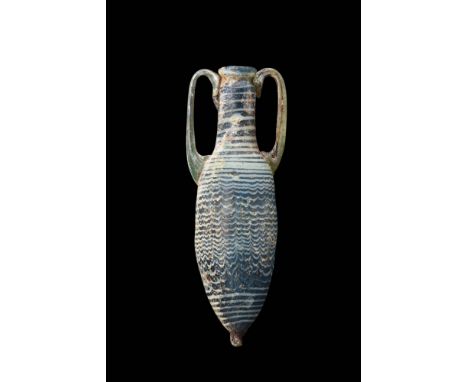 Ca. 200 BC.A deep blue and white core-formed glass amphoriskos with a tapered body decorated with a fine overall bluish-white