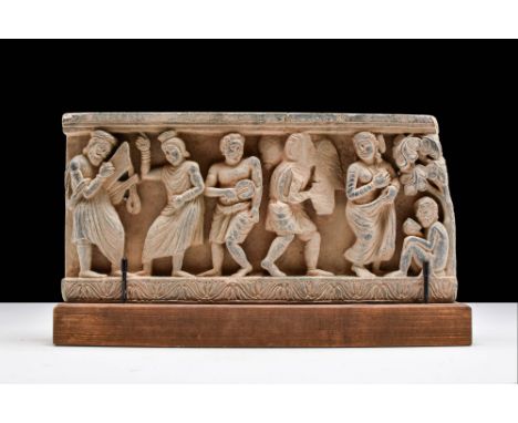 Ca. AD 100 - 200.A rectangular frieze featuring a relief with a scene of a banquet. The men in the scene are depicted playing