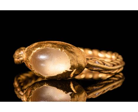 Ca. AD 600 - 800.A Saxon 22 ct gold ring. It has a round band with braided edges. The ring features an attached domed bezel e