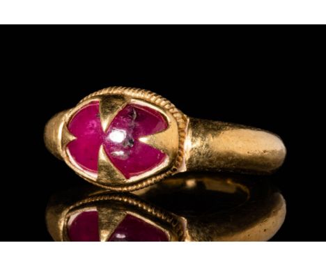 Ca. AD 900 - 1000 .A Javanese 18 ct gold ring with ruby cabochon set in oval bezel decorated with a filigree line around. It 