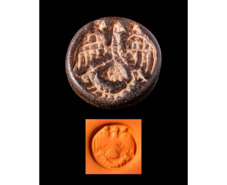 Ca. 2300 - 1800 BC.A round Bactrian stamp seal depicting an eagle with its wings spread and a background of stars in the sky.