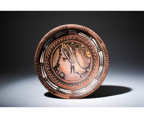 Ca. 320 - 300 BC.A black-glazed raised plate, featuring a red-figure decoration with yellow and white details. It is embellis