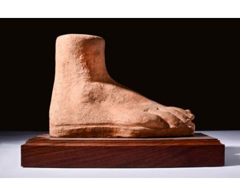 Ca. 600 BC.A moulded red pottery votive foot, depicted with very naturalistic toes and form, with a vent hole at the top. The