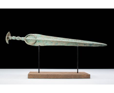 Western Asiatic/Aegan, Ca. 1200 - 700 BC.A bronze sword with a long tapering blade, featuring a raised mid-rib and a curved g