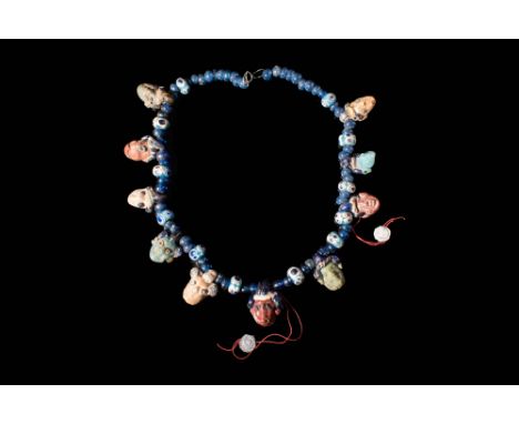 Ca. 500 - 300 BC.An amazing Phoenician necklace with ten unique head shaped glass pendants. The necklace is comprised of doze