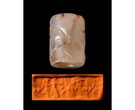 Ca. 800 - 600 BC.A Neo-Assyrian chalcedony cylinder seal depicting a standing god wearing a long, decorated tunic. The figure