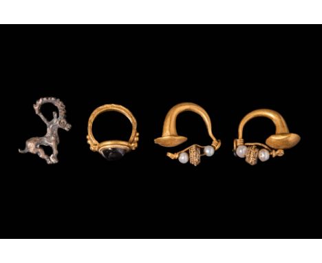 Ca. 1st Millenium BC.A pair of gold earrings reel-shaped with a cylindrical body closed with two decorated discs and concentr