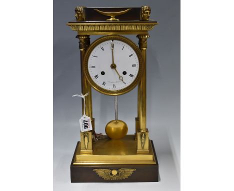 A 19TH CENTURY FRENCH EGYPTIAN REVIVAL BRASS PORTICO FORM CLOCK, frieze with mask designs to the corners, raised on four colu