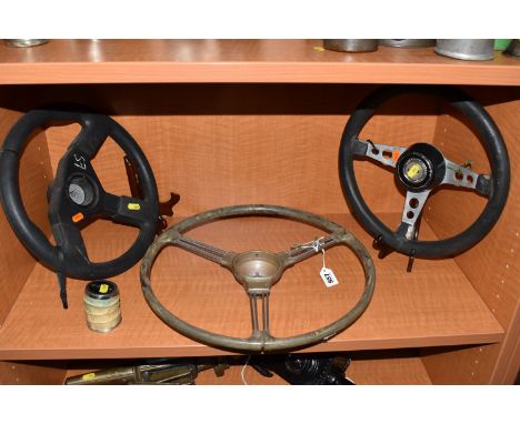 THREE STEERING WHEELS AND A PIRELLI WHEEL CENTRE comprising a Mini steering wheel, diameter 34cm (plastic cover to the centre
