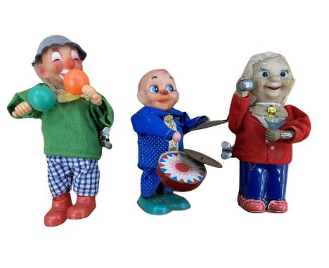 A trio of rubberised clockwork toys, to include: - Clown playing maracas - Bartender - Percussionist