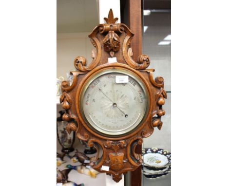 A late 19th Century Negretti and Zambra of London barometer, silvered dial, No. 5178, carved oak frame 