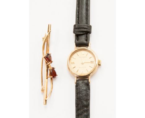 A ladies' 9ct gold Tissot watch of leather strap together with a 9ct gold garnet set bar brooch 