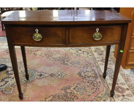 An early 20th Century mahogany side table, of bow fronted form, fitted with two drawers, raised on square legs