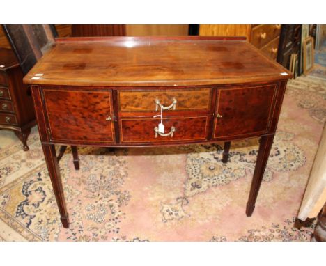 An early 20th Century George III style bow fronted sideboard, fitted with two drawers and two doors, raised on square legs