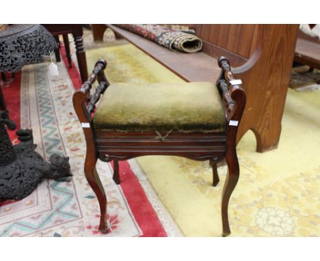 An Edwardian piano stool, the seat opening to reveal a manuscript section, raised on shaped legs