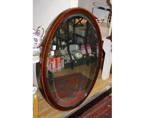 An oak cased stick barometer and an Edwardian oval mahogany framed wall mirror (2) 