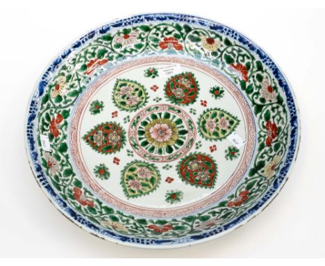 A Chinese polychrome charger, Kangxi, the centre with Islamic style floral motifs bordered in green foliate scroll design and