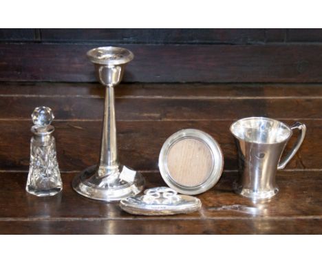 A group of silver items including a weighted candle stick (af) a Christening mug, a small round photo frame, nail buffer, a s