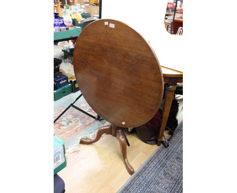 A George III mahogany tripod table, raised on a turned column, standing on cabriole legs