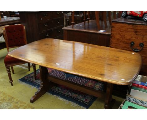 An Ercol elm dining table, with a trestle base and six dining chairs