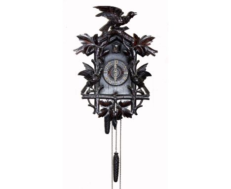 A Black Forest cuckoo clock carved with leaves and singing birds centred by dial with Roman numerals, with two train movement