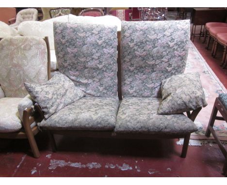 An Ercol two seater sofa with a shaped ladderback and loose floral back and seat cushions 130cm wide