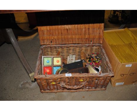 A wicker picnic basket and contents of mantel clock, napkin rings, bosuns wall clock, enamel chamber sticks etc