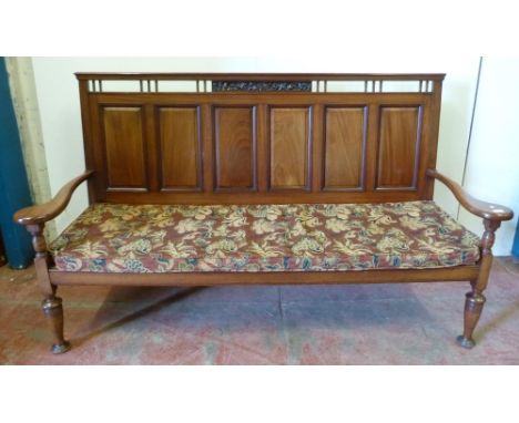 Aesthetic-style mahogany hall bench, the panelled back with fruit and vine carvings, scroll arm rests, on turned supports, 11