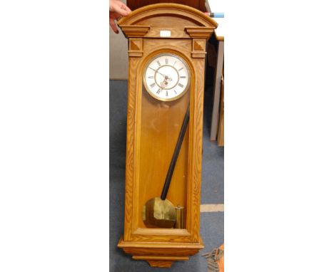 Vienna single-weight wall clock, the white enamel dial with Roman numerals, glazed viewing window, cased in oak, with brass w