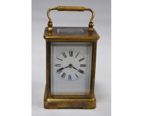 Brass four glass carriage clock with viewing window to the top displaying the movement, the white enamel dial with Roman nume