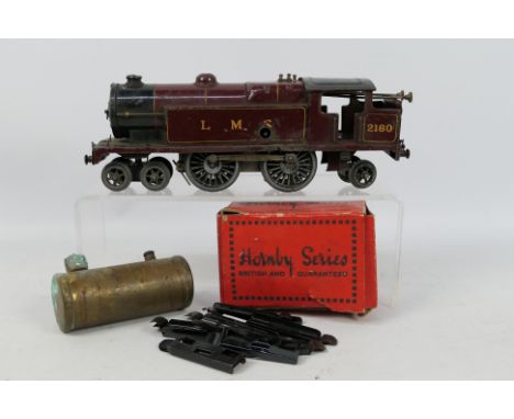 Hornby - A 1930s clockwork tinplate O gauge 4-4-2 tank engine number 2180 in LMS maroon livery. It shows signs of and and use