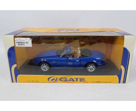 Gate - A boxed Mazda MX-5 in 1:18 scale in Twilight Blue Mica. The car appears in Mint condition in a Good box with some ligh