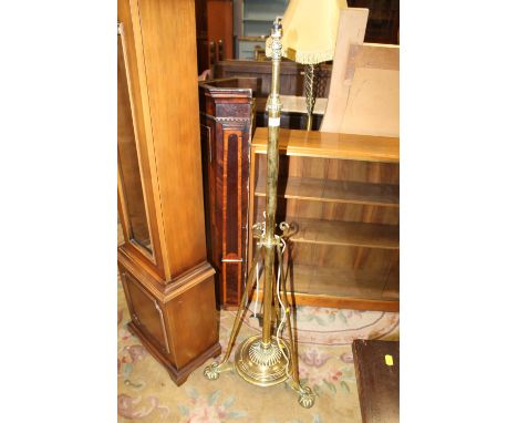AN ANTIQUE BRASS EXTENDING LAMP STANDARD